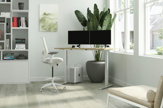 Focusory modern ergonomic home office with an adjustable standing desk, dual monitors, and natural light from large windows