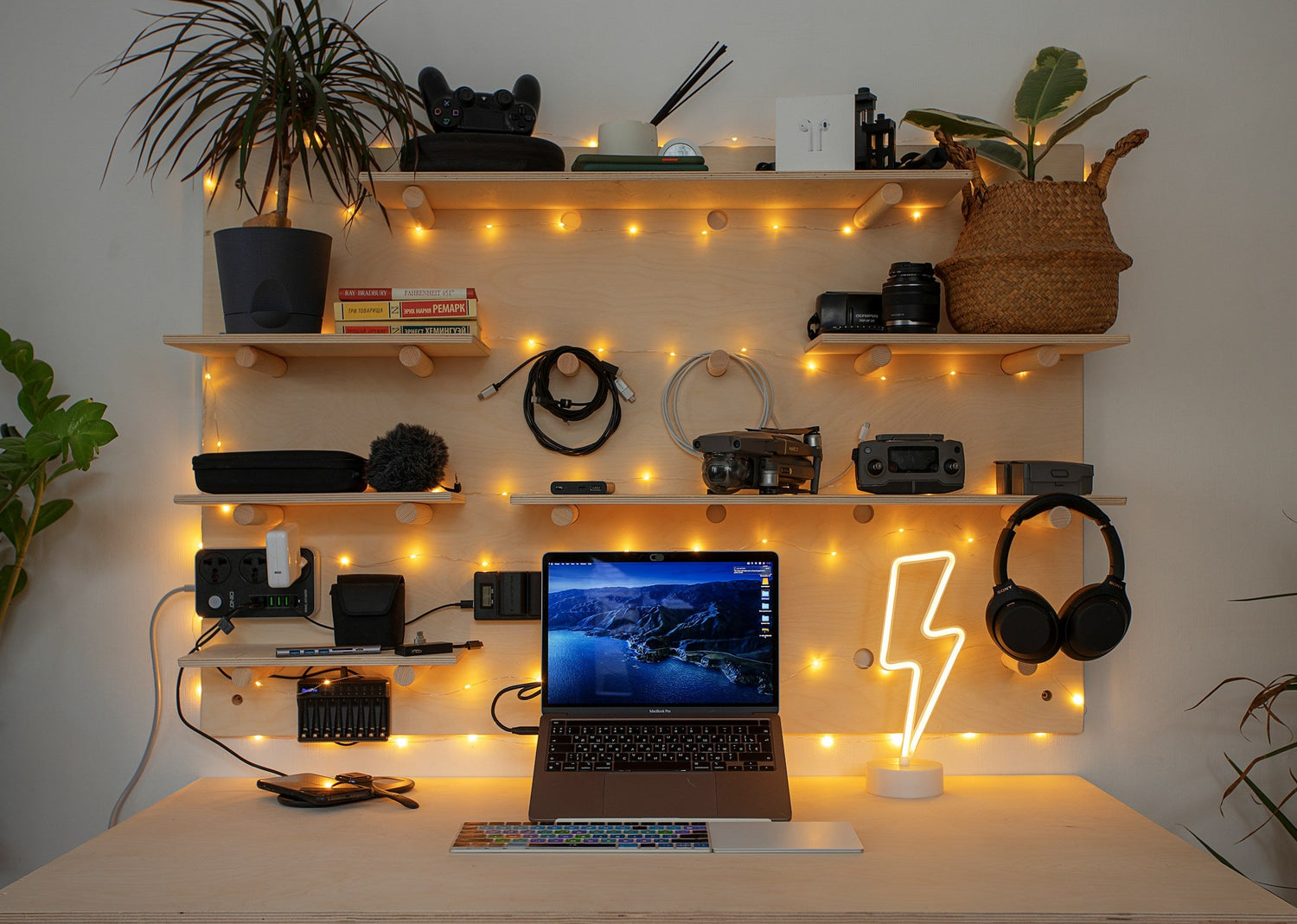 Creative workspace with pegboard, laptop, LED lamp, tech gear, and warm lighting for inspiration