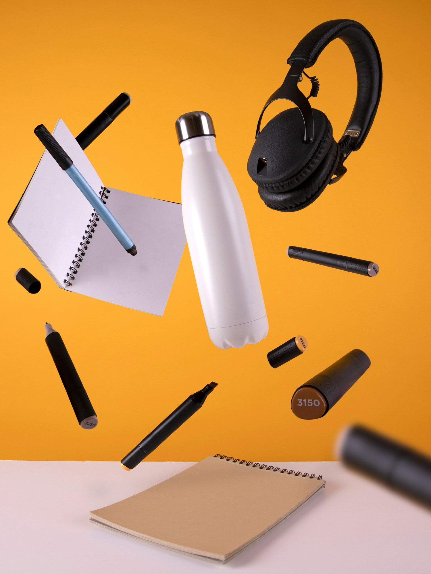 Floating study tools including notebooks, pens, bottle, and headphones on an orange background